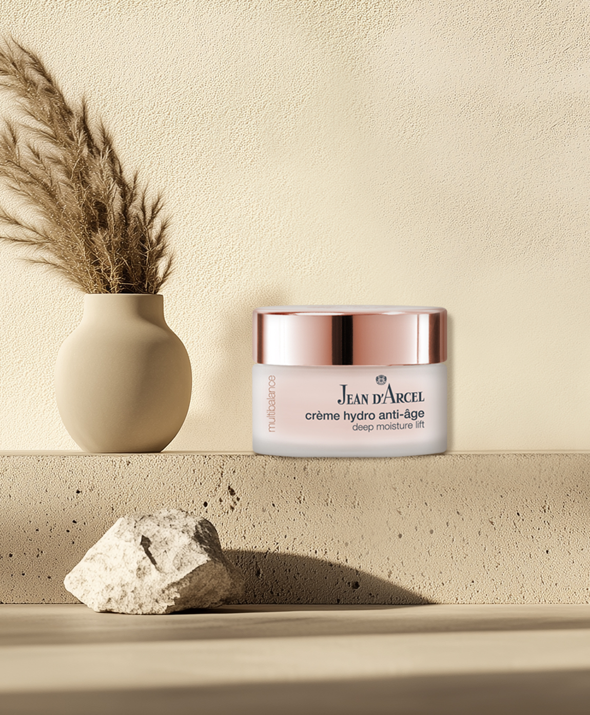 Creme-Tiegel auf einem Podest mit Deko-Elementen.